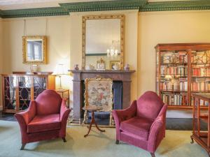 a living room with two chairs and a fireplace at The Laird's Wing - Brodie Castle in Forres