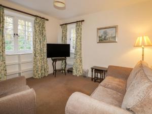 un soggiorno con divano e TV a schermo piatto di Cormack Lodge - Brodie Castle a Forres