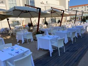 a beach with tables and chairs and umbrellas at Toscana Charme Resort in Tirrenia