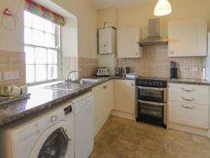 uma cozinha com uma máquina de lavar roupa e um lavatório em Royal Artillery Cottage - Culzean Castle em Maybole