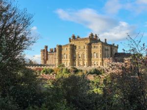 a castle on top of a hill with trees at Royal Artillery Cottage - Culzean Castle in Maybole
