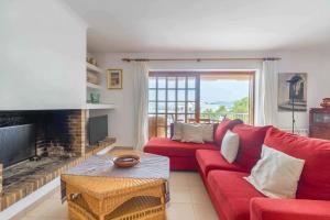 ein Wohnzimmer mit einem roten Sofa und einem Kamin in der Unterkunft Casa Mar in Ibiza-Stadt