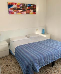 1 cama en un dormitorio con una pintura en la pared en Albergo Moderno, en Módena