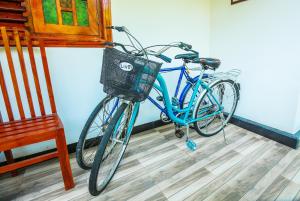 Yala New Nehansa Resort في تيساماهاراما: دراجة زرقاء متوقفة في غرفة بجوار كرسي