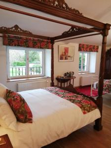 a bedroom with a large bed with a canopy at Le Grand Chemin de La Vie in Montcaret