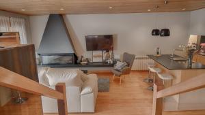 a living room with a white couch and a kitchen at Saplan Real Estate SARRAERA in Vielha