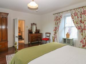 a bedroom with a bed and a dresser and a window at Courtyard Cottage - Drum Castle in Banchory