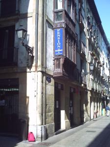 un edificio con un cartello blu sul lato. di Pensión la Marinera a San Sebastián