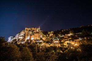 a town on top of a mountain at night at Le Bois d'Imbert in Rocamadour
