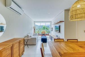 a kitchen and living room with a large window at C15 - Conforto junto a natureza - Camburyzinho in São Sebastião