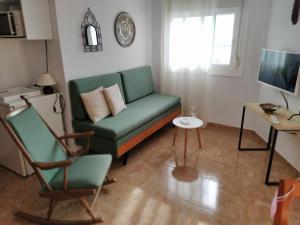 ロス・クリスティアーノスにあるApartamento Playa Los Cristianosのリビングルーム(緑のソファ、テーブル付)