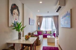 een woonkamer met een bank en een tafel bij The Astra Condo City Center Chiang Mai in Chiang Mai