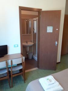 Camera dotata di bagno con lavandino e servizi igienici. di Hotel Solaria a Marina Romea