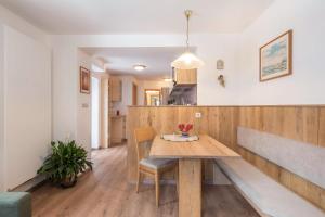 eine Küche und ein Esszimmer mit einem Holztisch in der Unterkunft Apartment Santer Villa Erna in Seis am Schlern