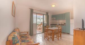 Una sala de estar con un sofá y una mesa con sillas. en Apartamentos Moon Dreams Los Lentiscos, en Cala en Blanes