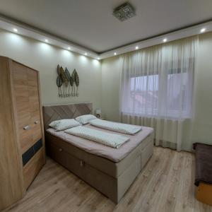 a bedroom with a bed and a large window at Ancsi Apartmant Kecskemét in Kecskemét