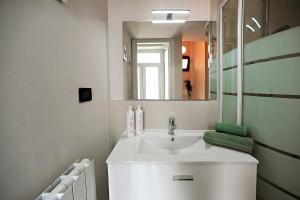 a bathroom with a white sink and a mirror at Modern Apartment in Lingotto Area by Wonderful Italy in Turin