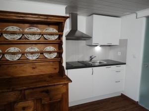 una cocina con armarios blancos y fregadero en Bis Bosserte en Kollbrunn