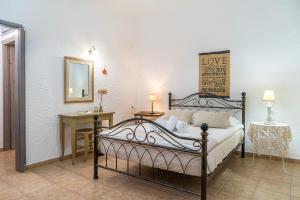 a bedroom with a bed and a desk and a mirror at Villa Plori in Makry Gialos