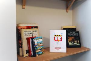 uno scaffale con alcuni libri sopra di Modern Apartment in Lingotto Area by Wonderful Italy a Torino
