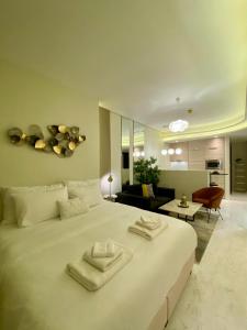 a bedroom with a large white bed and a living room at Bahrain bay studio in Manama