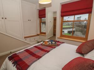a bedroom with a bed with a plaid blanket on it at Losehill View in Castleton