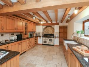 a large kitchen with wooden cabinets and a stove at Varley Lodge in Barnstaple