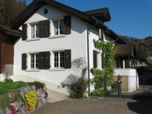 ein weißes Haus mit braunen Fenstern und einem Zaun in der Unterkunft Bis Bosserte in Kollbrunn