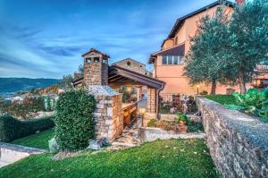 une maison sur une colline avec un mur en pierre dans l'établissement Guest House Nena, à Motovun