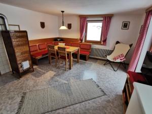 ein Wohnzimmer mit einem Sofa, einem Tisch und Stühlen in der Unterkunft Ferienwohnungen Böhm in Sankt Jakob in Defereggen