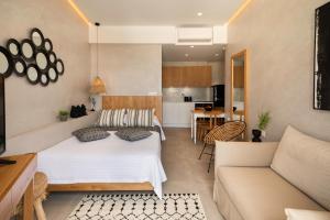 een slaapkamer met een bed en een woonkamer bij Petalo Suites in Rethimnon