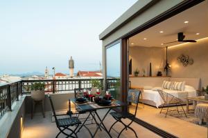 a balcony with a bed and a table and chairs at Petalo Suites in Rethymno Town