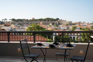 un tavolo e sedie su un balcone con vista di Petalo Suites a Rethymno