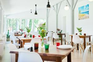 een restaurant met houten tafels en witte stoelen bij Ośrodek Wypoczynkowy Cubex in Stegna