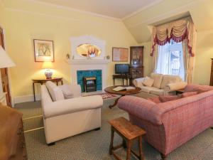a living room with two couches and a fireplace at Braeriach - Mar Lodge Estate in Ballater