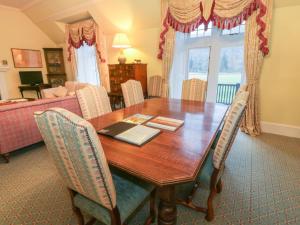 - une table à manger avec des chaises et un canapé dans l'établissement Braeriach - Mar Lodge Estate, à Ballater