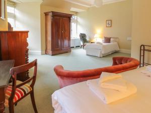 um quarto com uma cama, uma mesa e cadeiras em Bynack - Mar Lodge Estate em Ballater