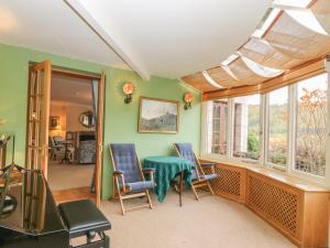 a room with a table and chairs and windows at Claybokie - Mar Lodge Estate in Ballater