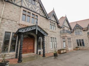 un gran edificio de ladrillo con puerta de madera en Derry - Mar Lodge Estate, en Ballater