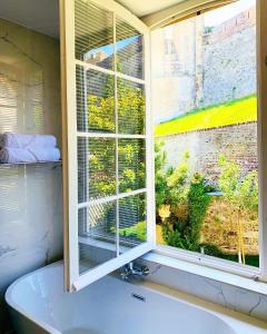 La salle de bains est pourvue d'une fenêtre et d'une baignoire. dans l'établissement Villa Castel Chambres d'hôtes B&B, à Dieppe