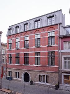 a large brick building with a large window at Amosa Liège City Centre Hotel in Liège