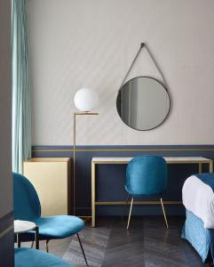 a living room with a chair and a mirror at Amosa Liège City Centre Hotel in Liège