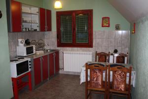 a kitchen with red cabinets and a table with chairs at Apartment Nikitovic in Žabljak
