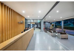 a lobby with people sitting at a bar at The Wind Hotel in Bang Sare