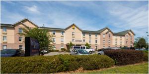 un gran edificio con coches estacionados en un estacionamiento en InTown Suites Extended Stay Chesapeake VA - Battlefield Blvd, en Chesapeake