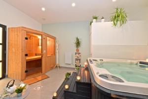 a large bathroom with a jacuzzi tub with plants at Chambres d'hotes Les Nuits Pastel in Saint-Quentin