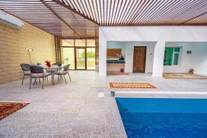a patio with a table and a swimming pool at Oriental Nights Rest House in Al Ghabbī