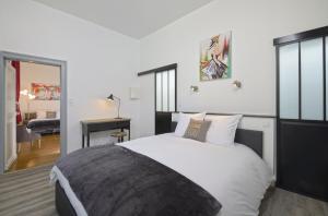 a bedroom with a large white bed and a living room at Hyper Centre Place Imbach in Angers