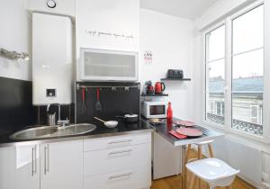 a white kitchen with a sink and a microwave at Hyper Centre Place Imbach in Angers