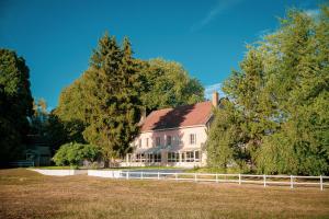 une grande maison blanche avec une clôture devant elle dans l'établissement Auberge du port, à Bazeilles